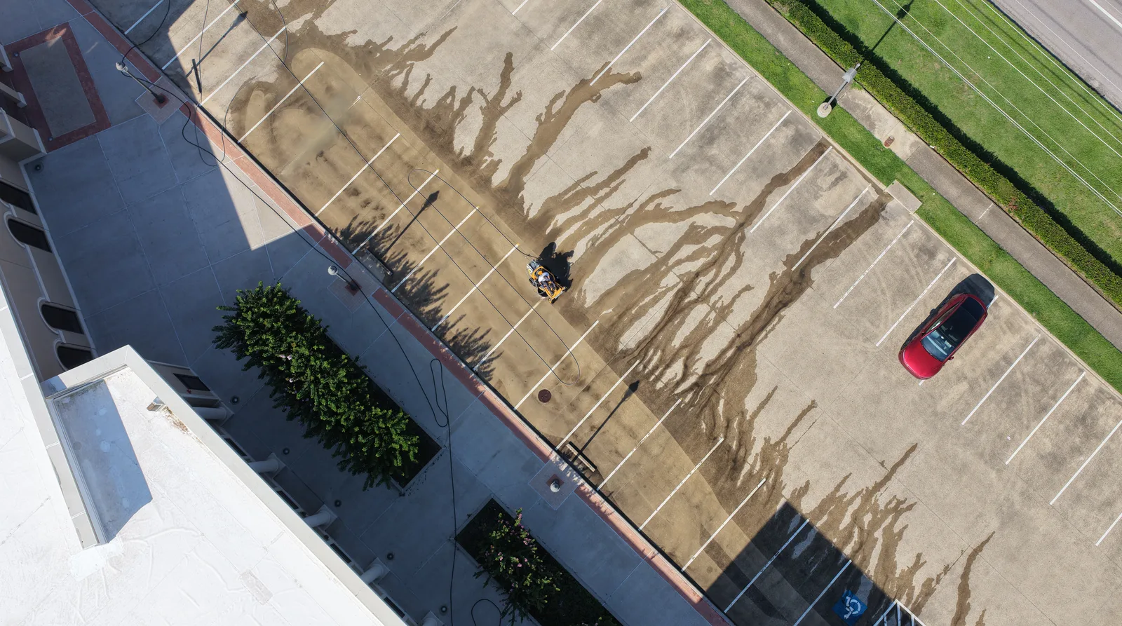 Drone view of a commercial parking lot being pressure washed