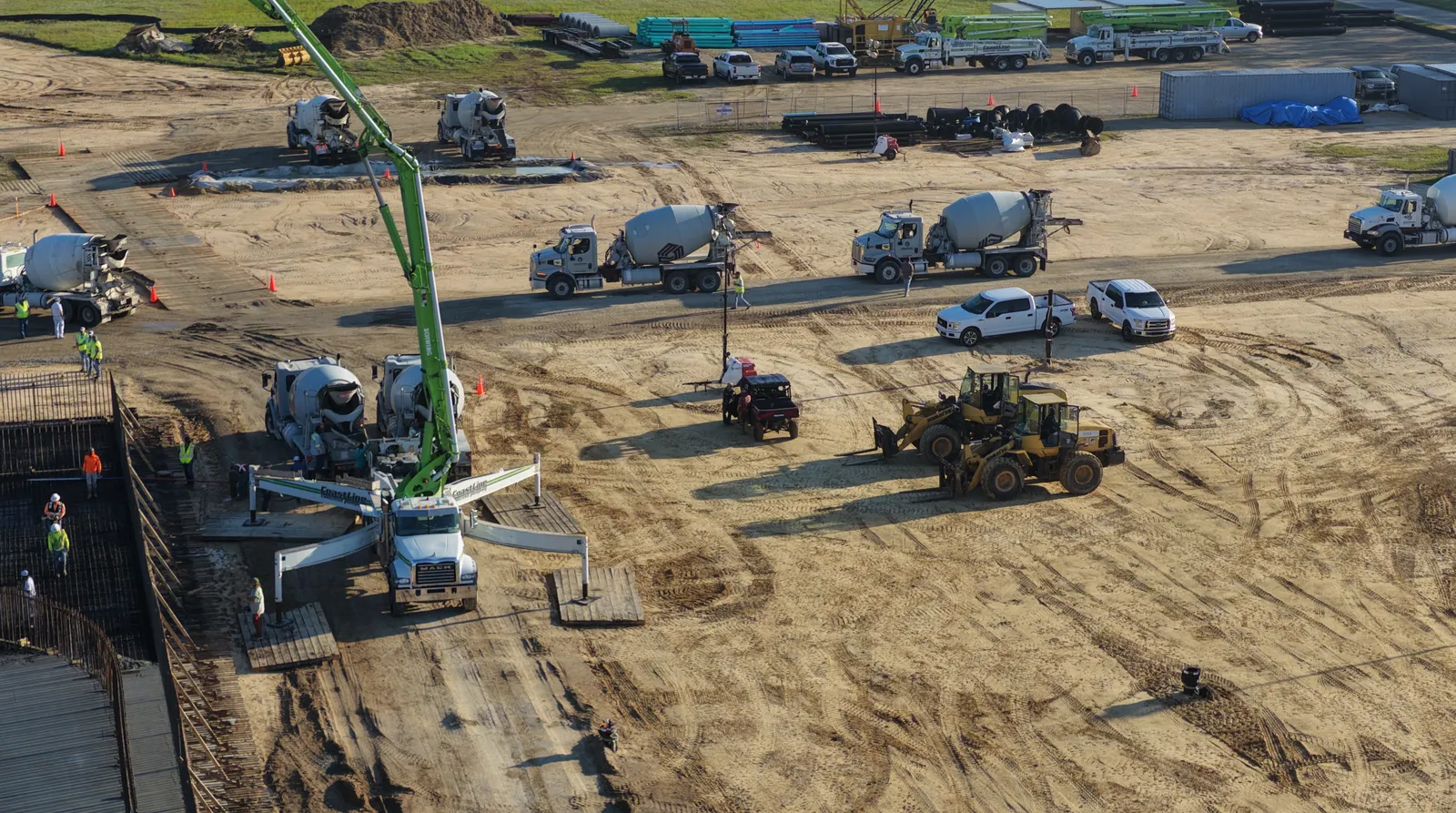 Drone photo of a concrete pump truck and mixer fleet on a large commercial pour